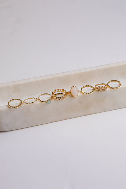 Set of gold rings on a marble surface with a light background