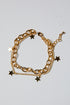 Gold chain bracelet with star charms on a light gray background