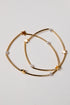 Gold hoop earrings with star and pearl accents on a light gray background