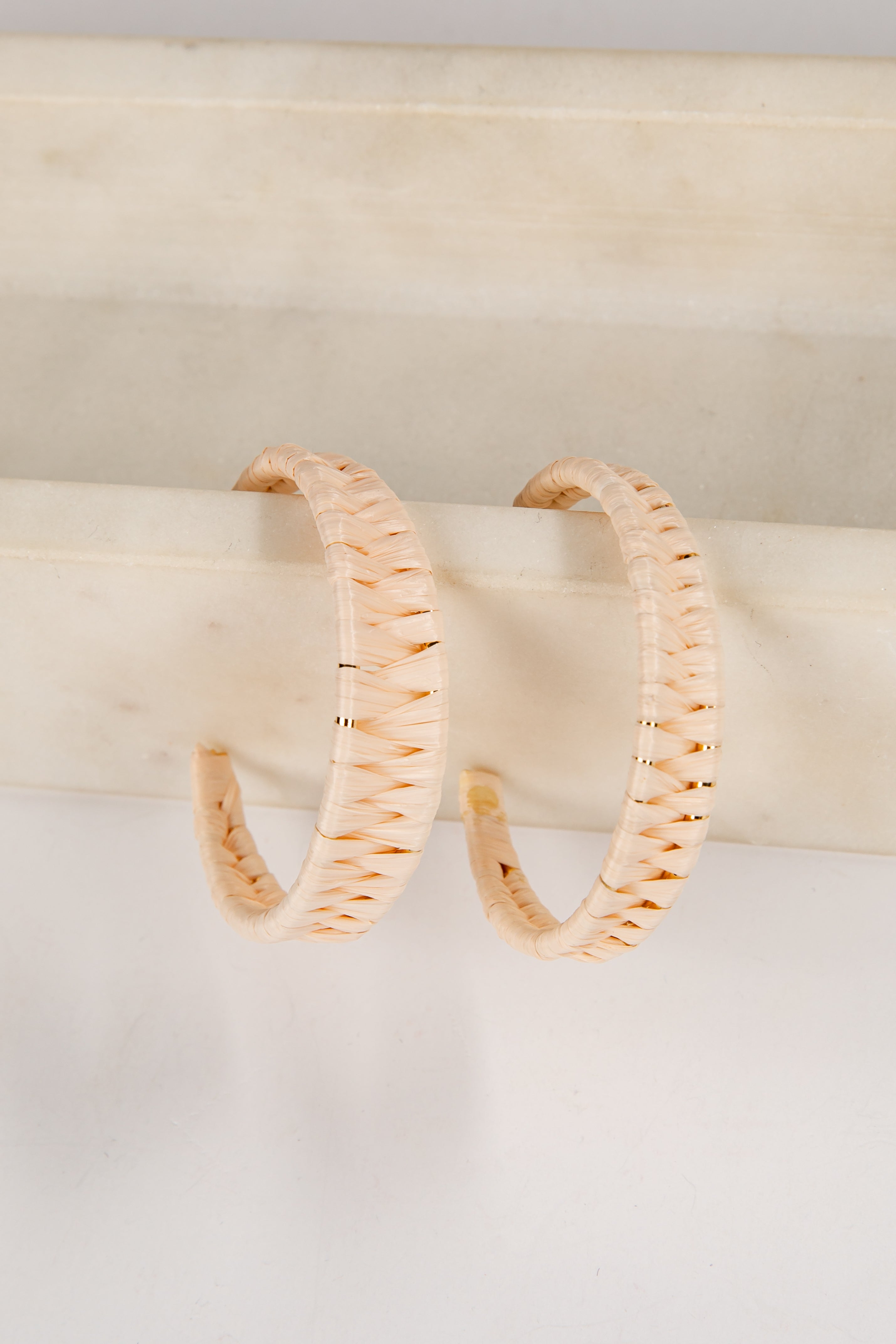 Pair of gold hoop earrings on a white surface