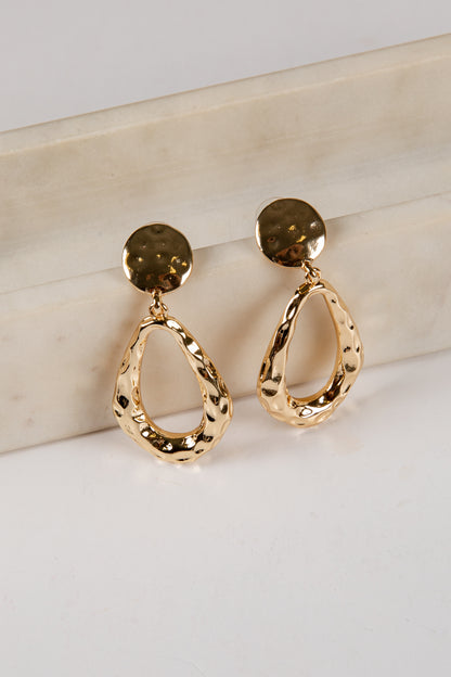 Gold hoop earrings on a light background