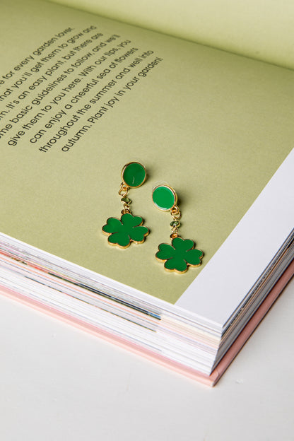 Green shamrock earrings on an open book