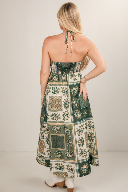 Woman wearing a floral and geometric patterned dress against a plain background