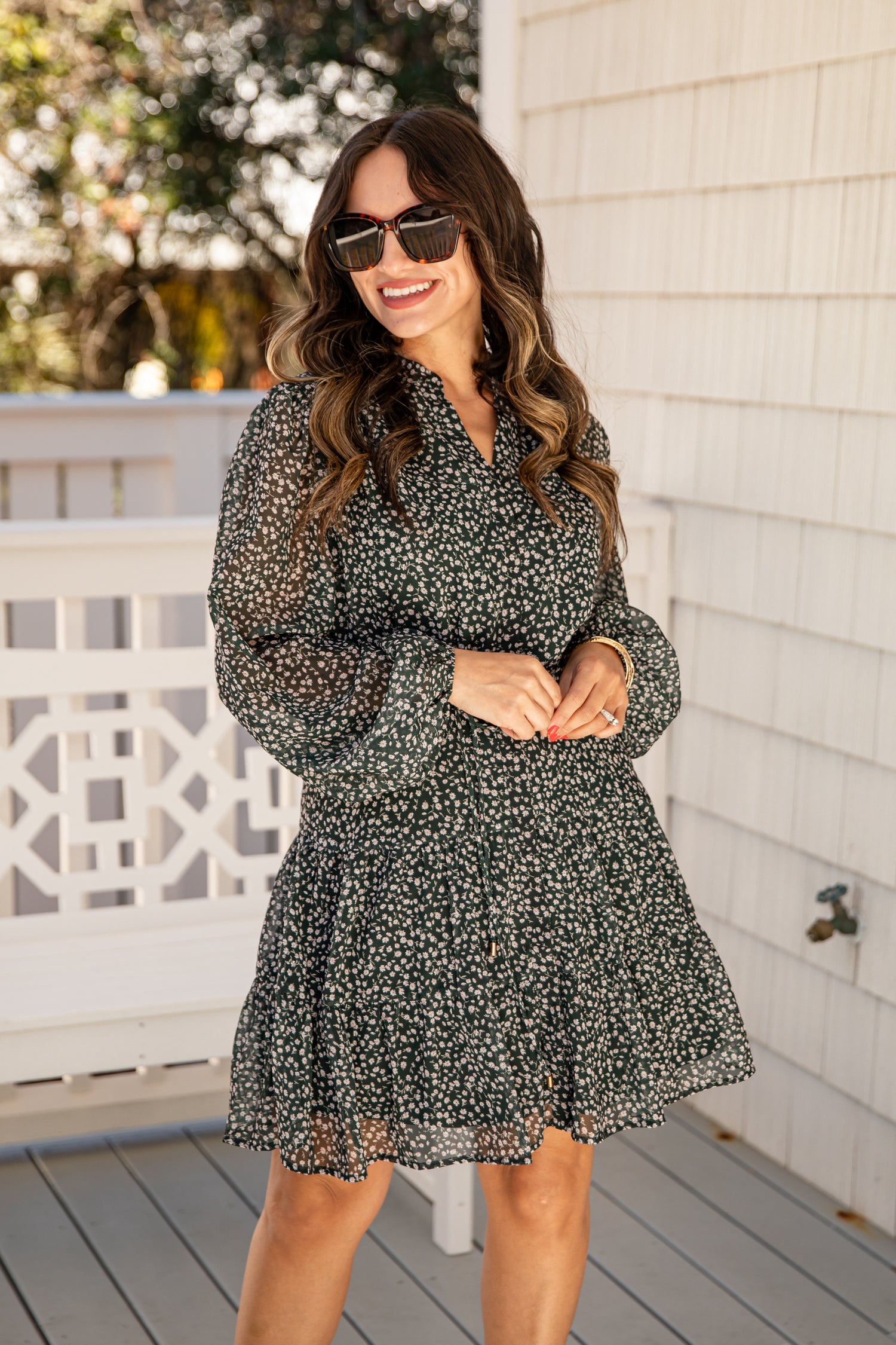 Woman wearing a floral dress on a wooden deck