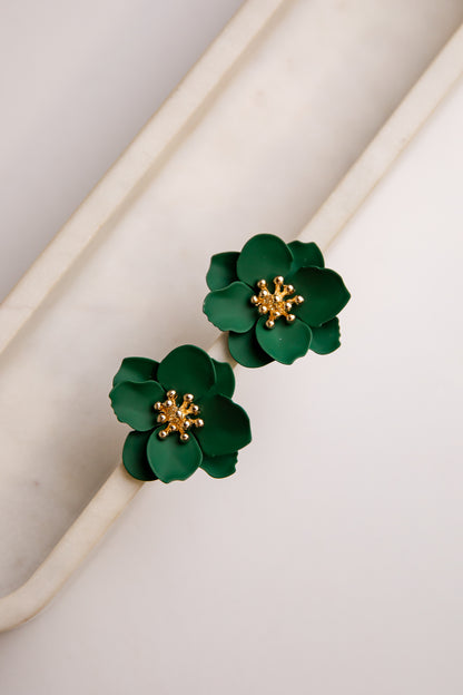 Green floral earrings with gold centers on a light background