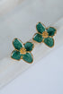 Green flower-shaped earrings with gold accents on a white surface