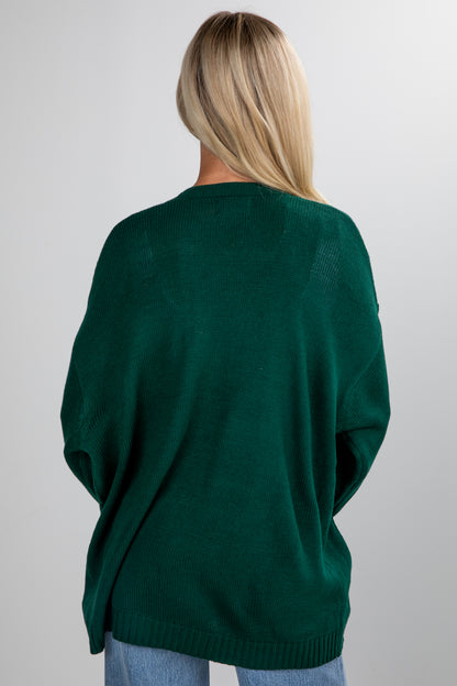 Person wearing a green sweater against a plain background