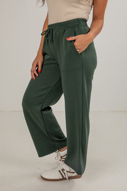 Person wearing green pants with a plain background