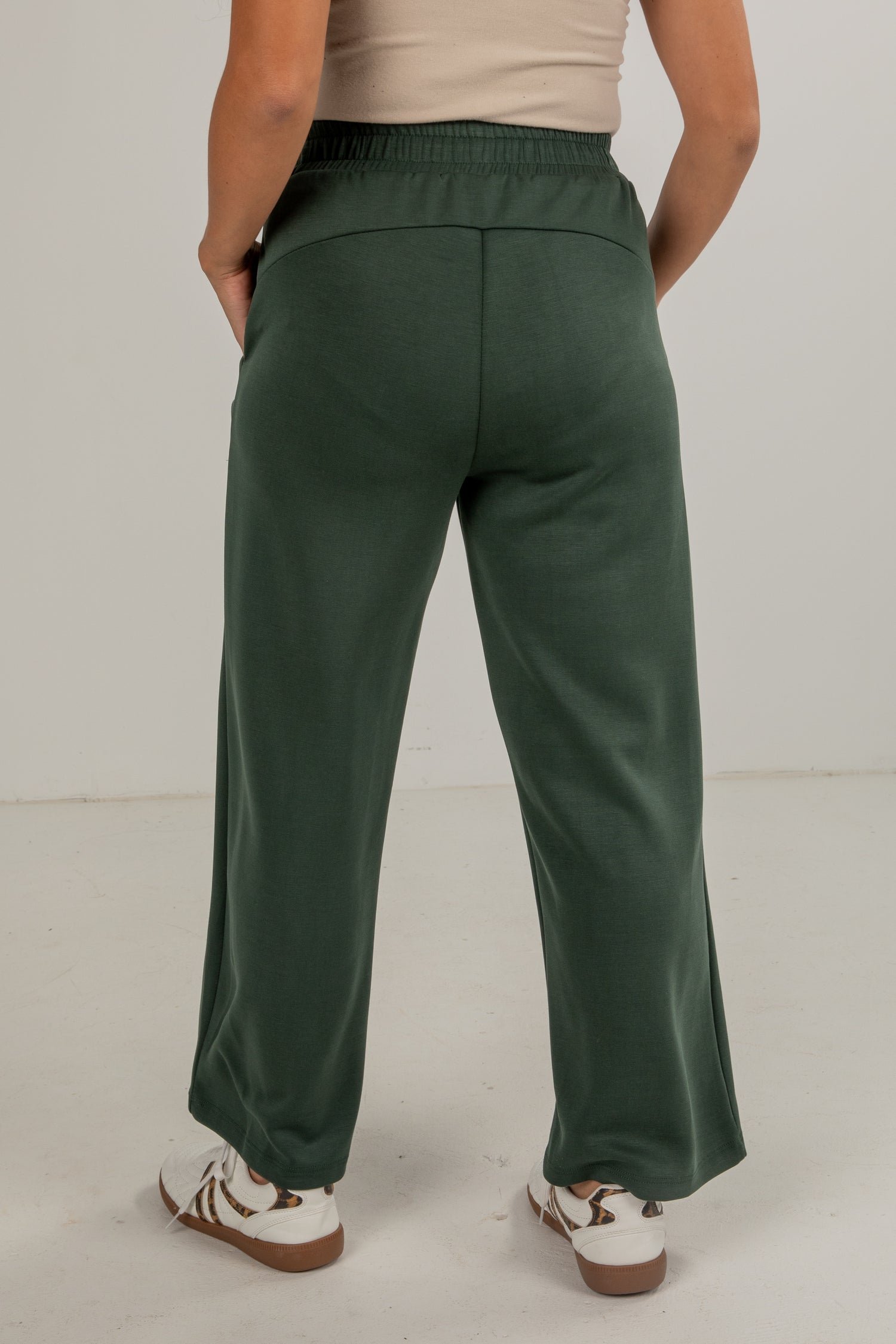 Person wearing green pants on a plain background