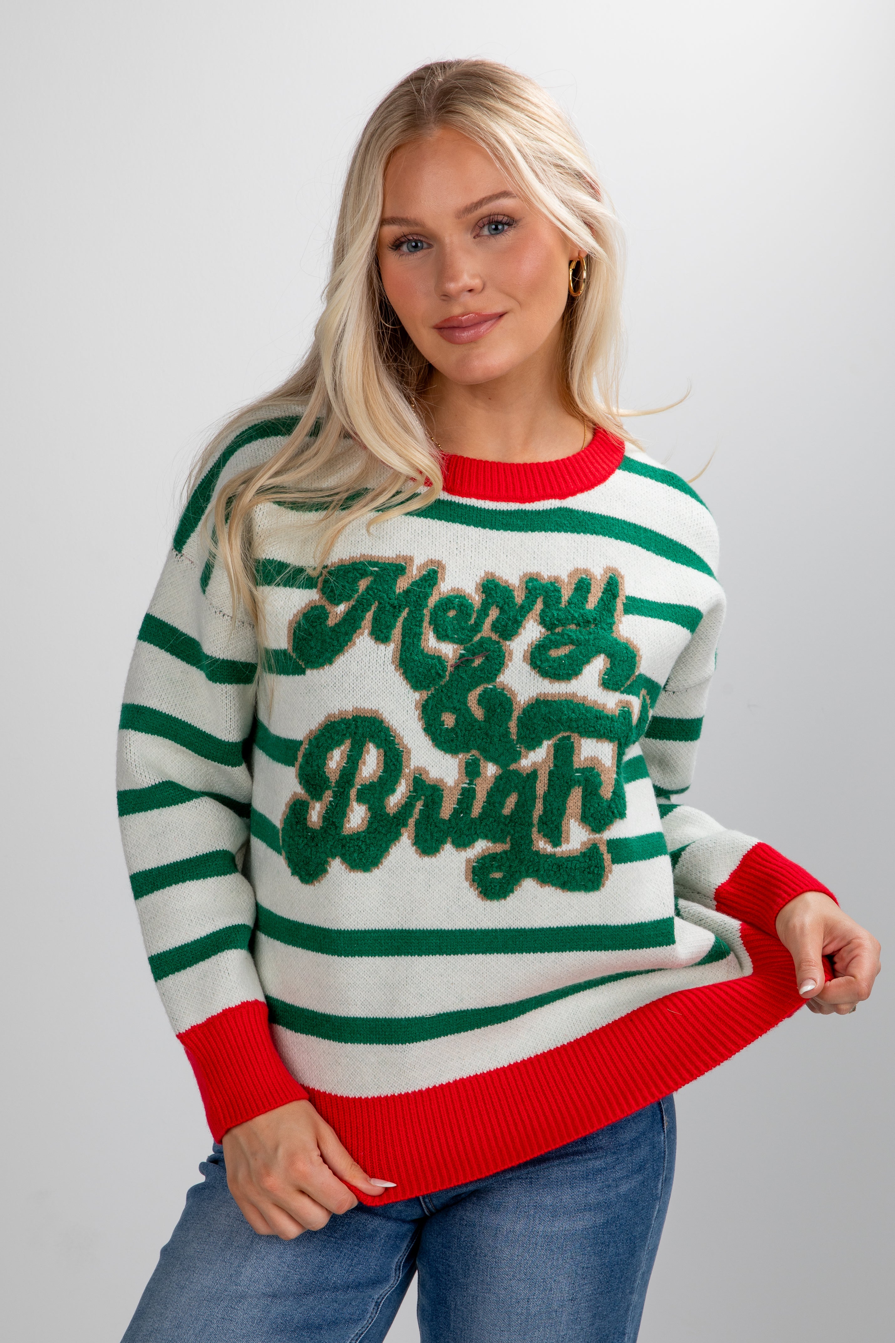 Woman wearing a green and red striped sweater with &