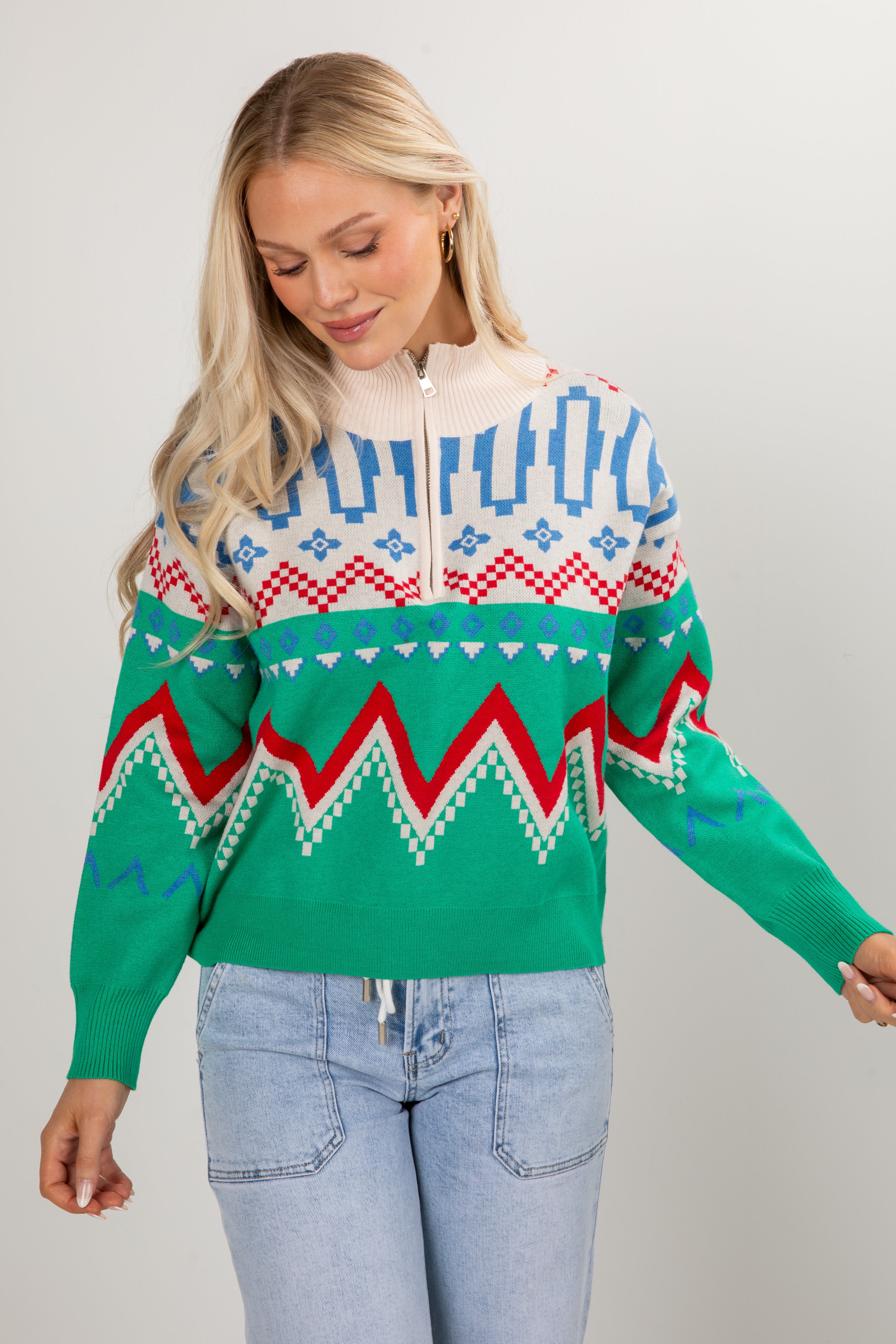 Woman wearing a colorful patterned sweater with a plain background