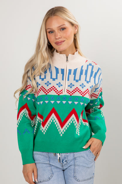 Woman wearing a colorful patterned sweater against a plain background