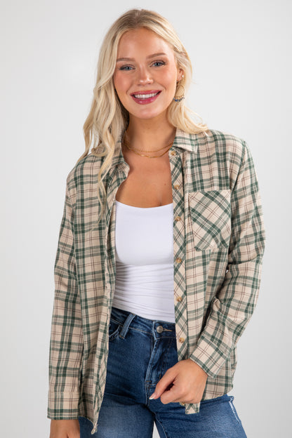 Woman wearing a plaid shirt over a white top and jeans on a white background