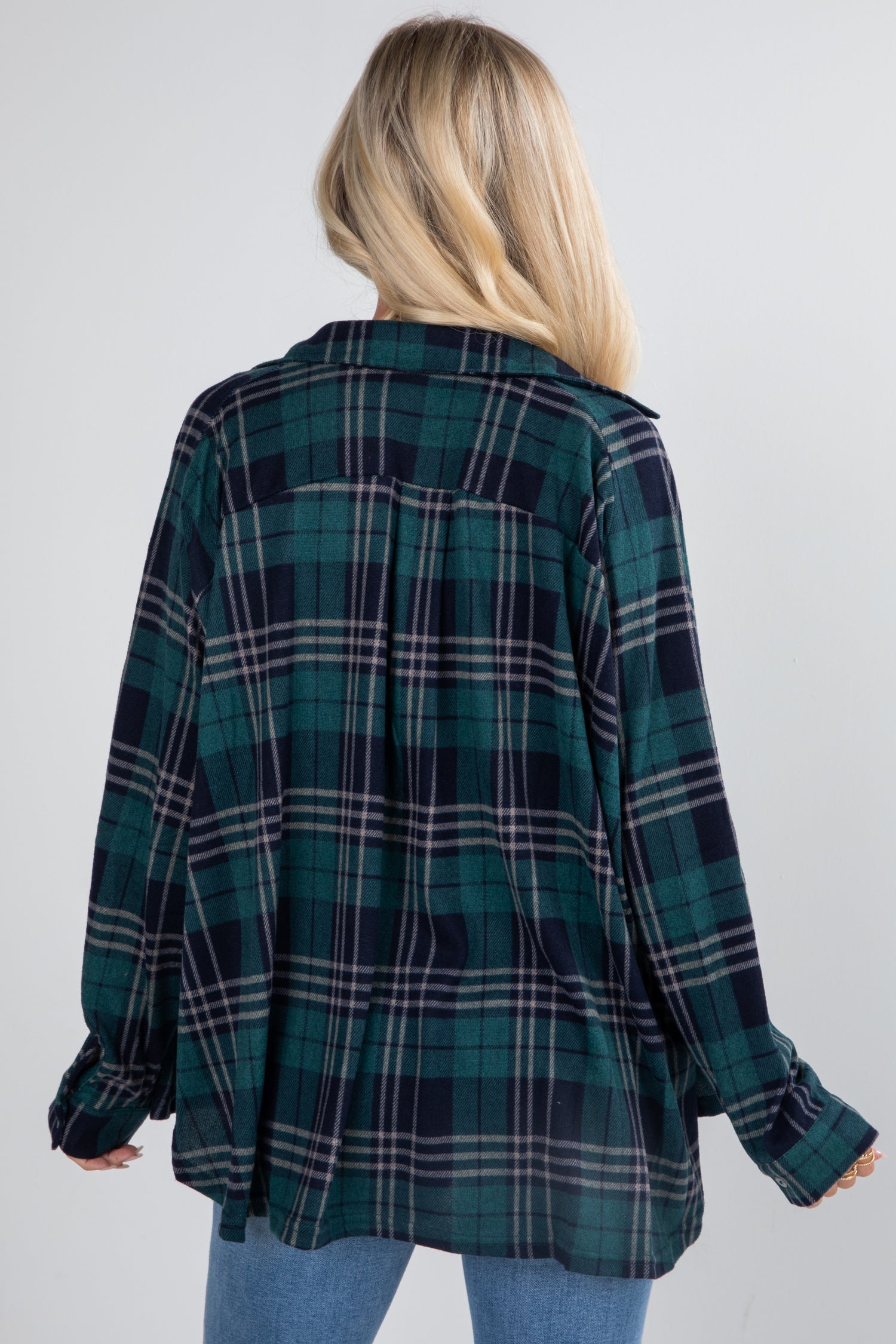 Person wearing a green and black plaid shirt on a white background
