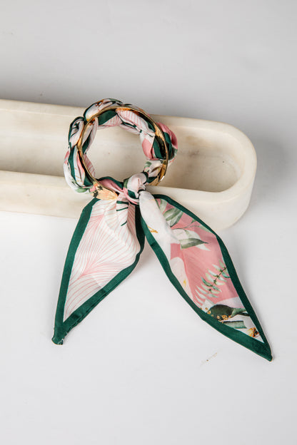 Floral scarf tied around a cylindrical object on a white background