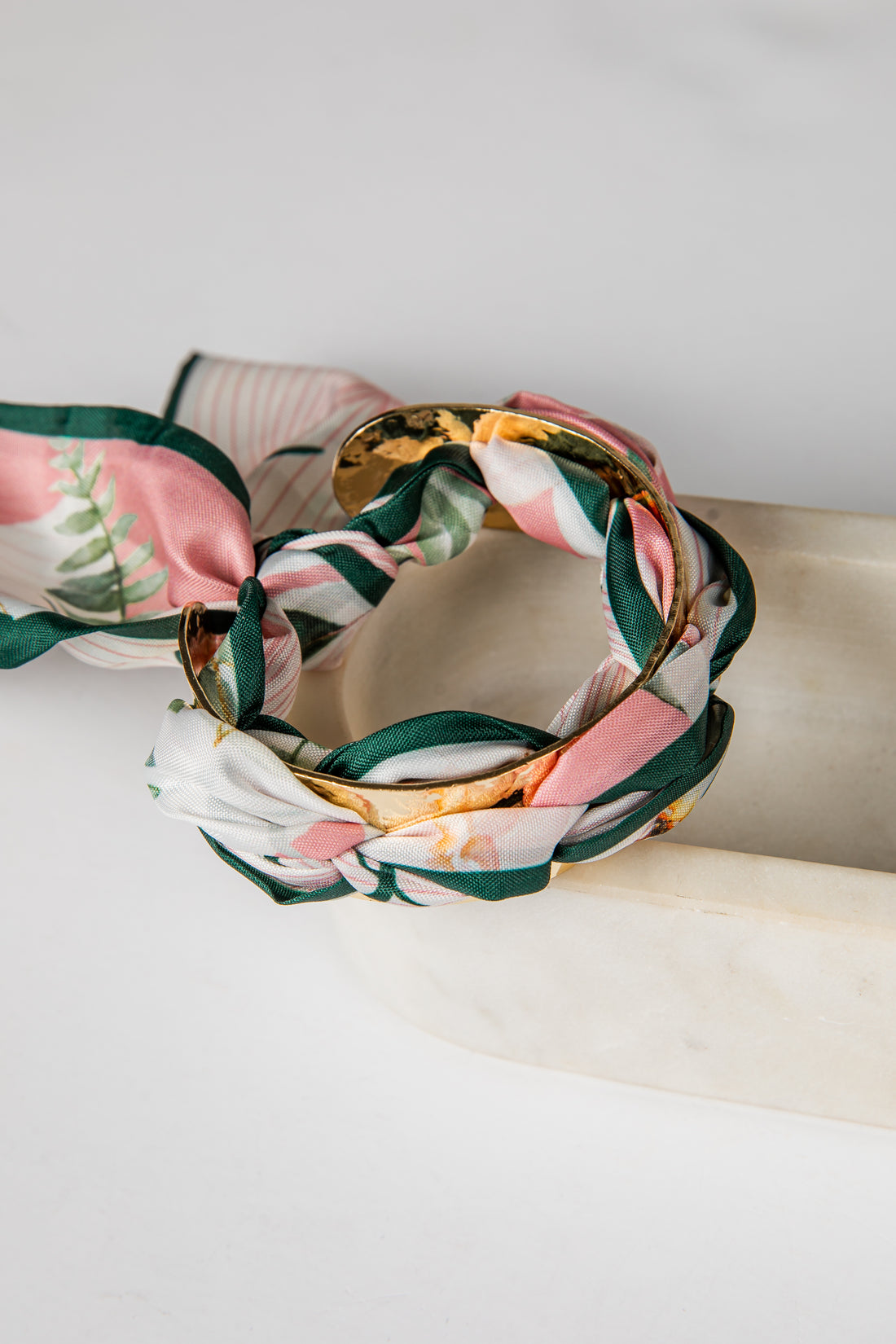 Floral bracelet on a white surface with a neutral background