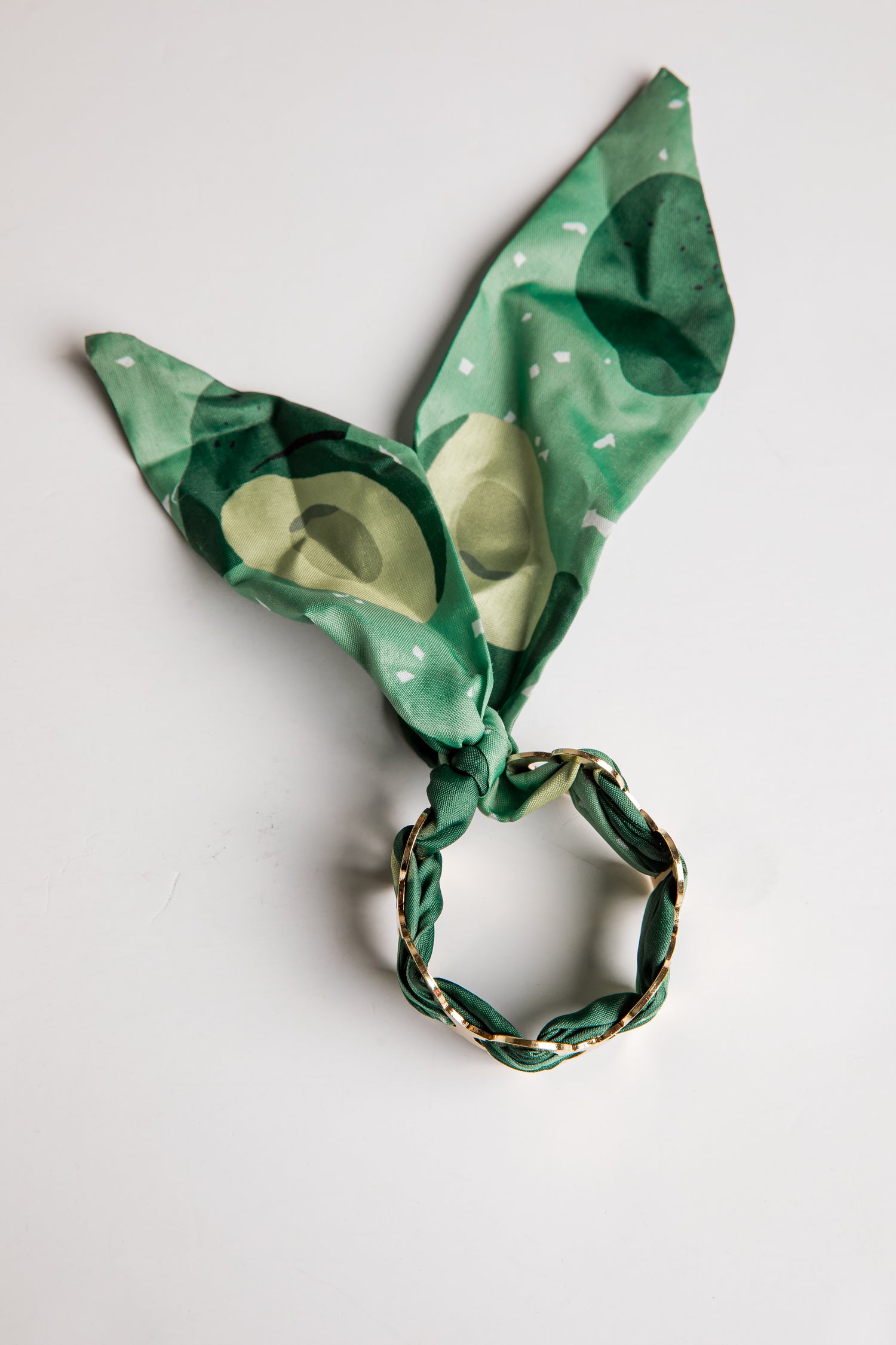 Green patterned bracelet with a gold accents on a white background