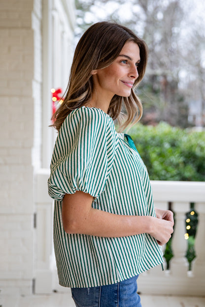 Woman wearing a green and white striped shirt on a porch