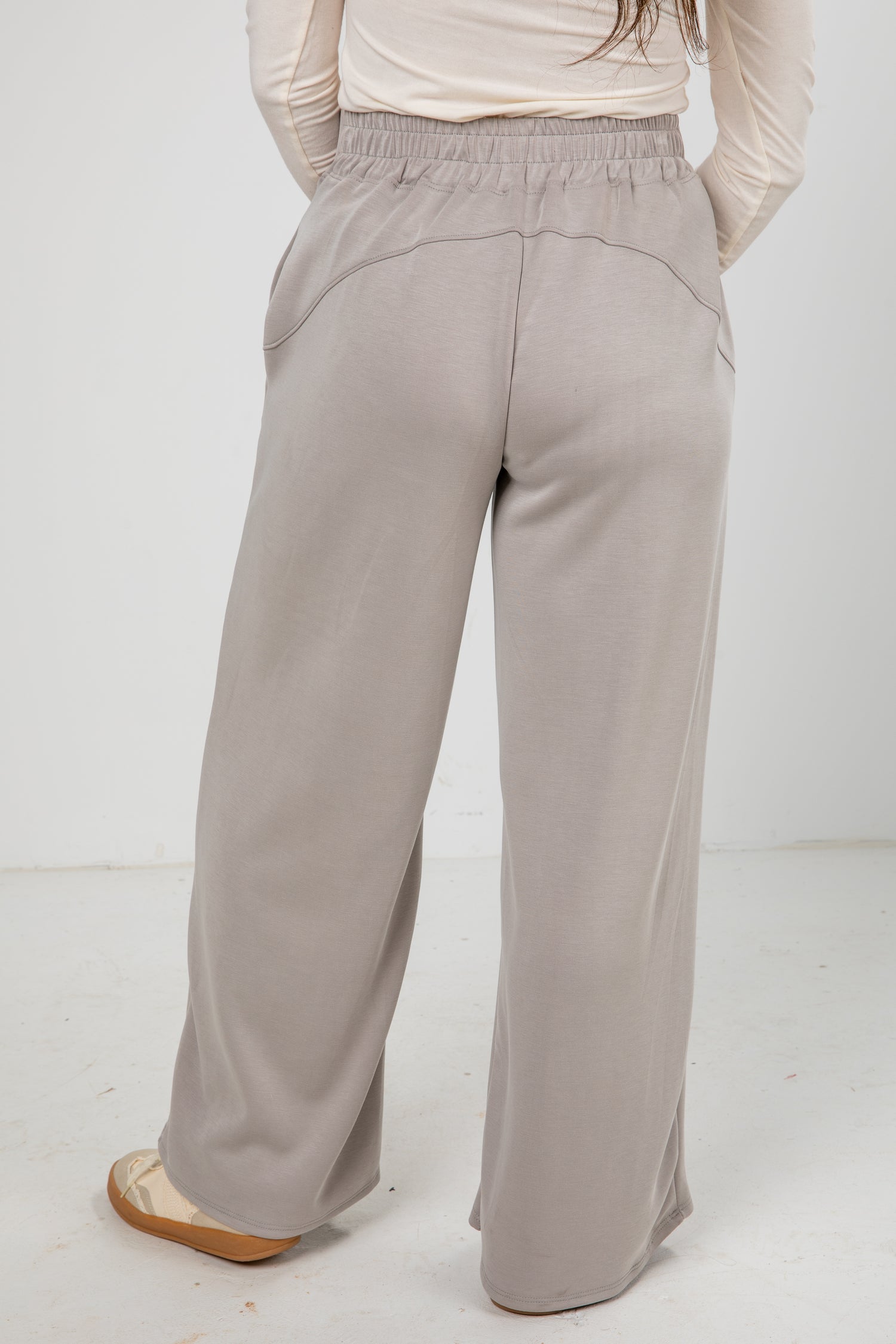 Light gray wide-leg pants worn by a person on a white background