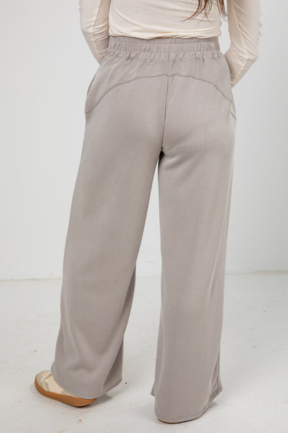 Light gray wide-leg pants worn by a person on a white background