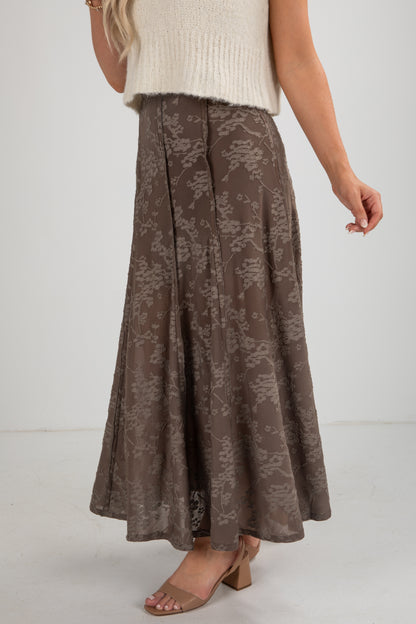 Brown floral-patterned skirt worn by a person on a white background