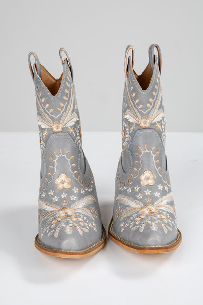 Pair of gray cowboy boots with floral embroidery on a white background