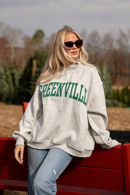 Woman wearing a gray sweatshirt with &