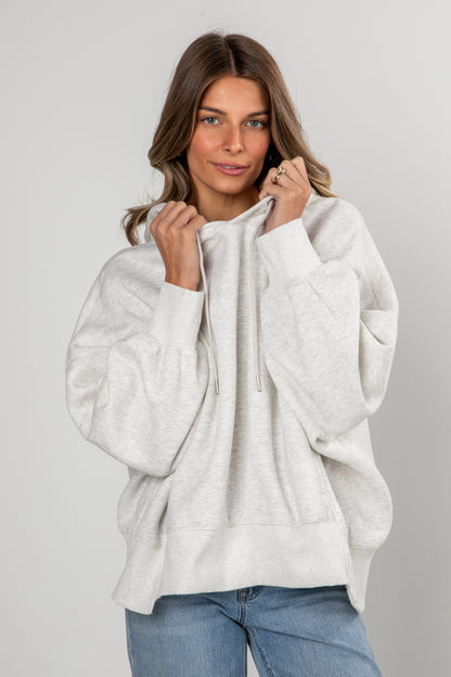 Woman wearing a white hoodie against a plain background