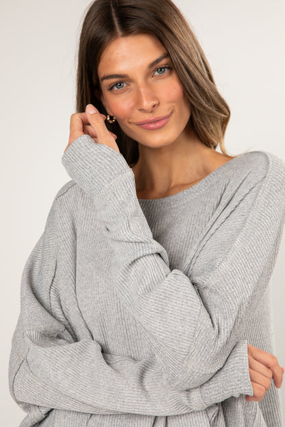 Woman wearing a gray sweater against a white background