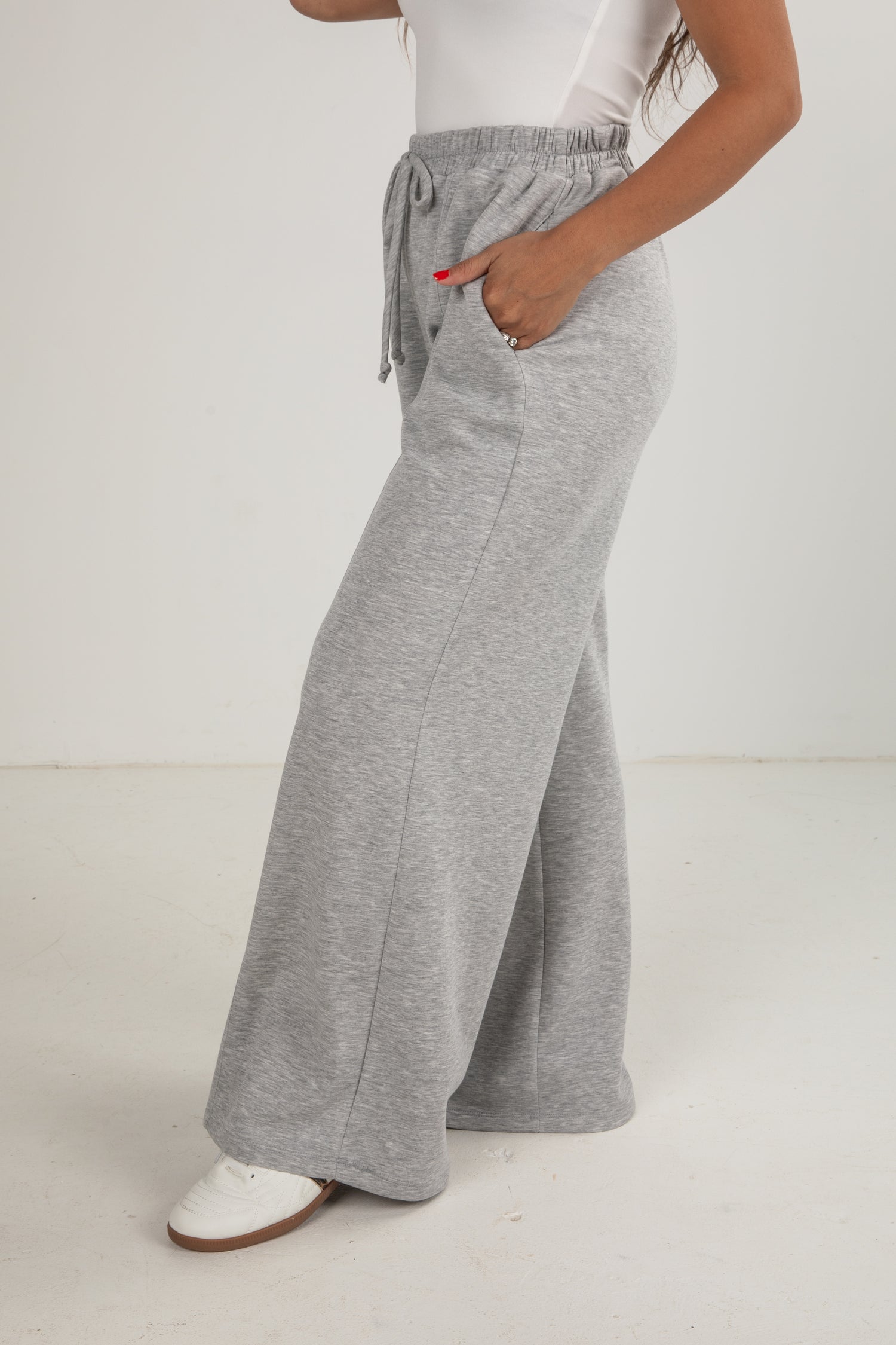 Person wearing gray wide-leg pants on a white background