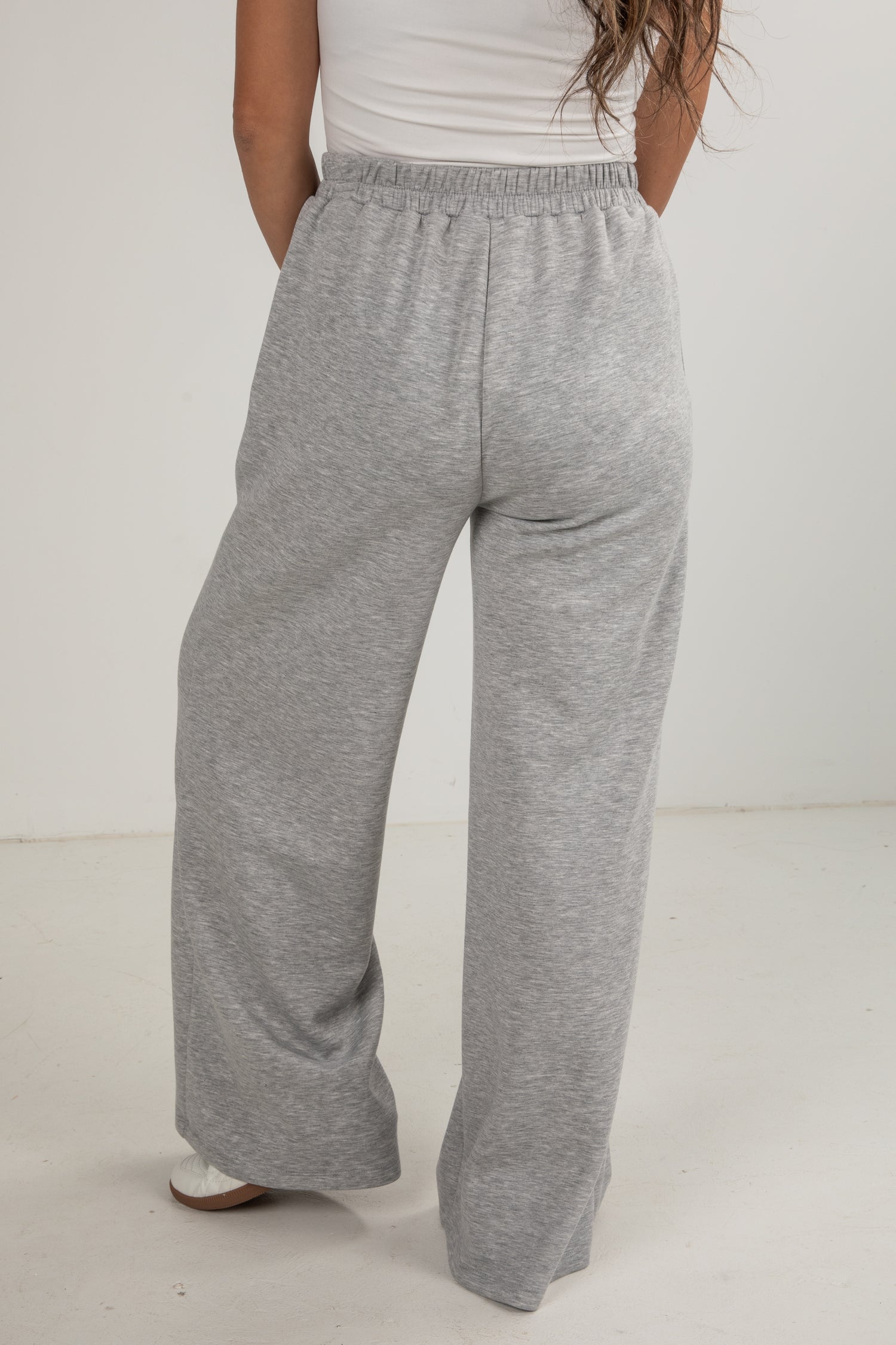 Person wearing gray sweatpants on a white background
