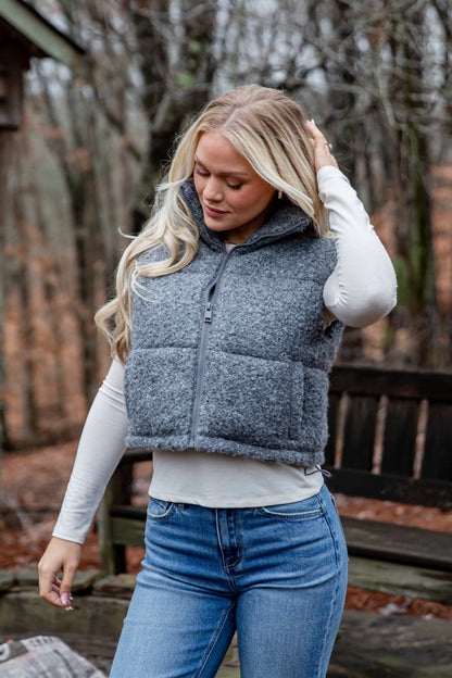 Woman wearing a gray puffer vest outdoors