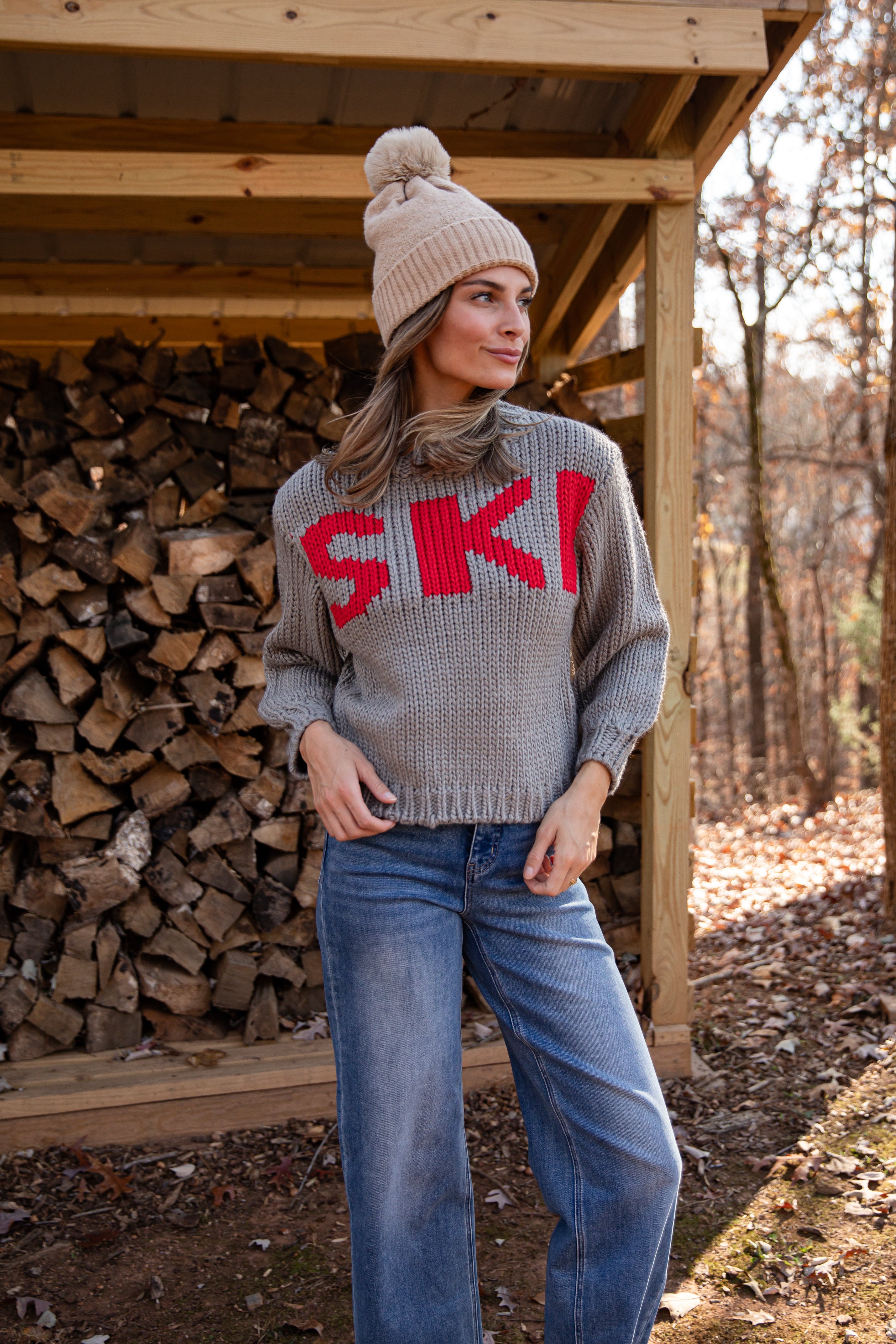 Woman wearing a gray sweater with &