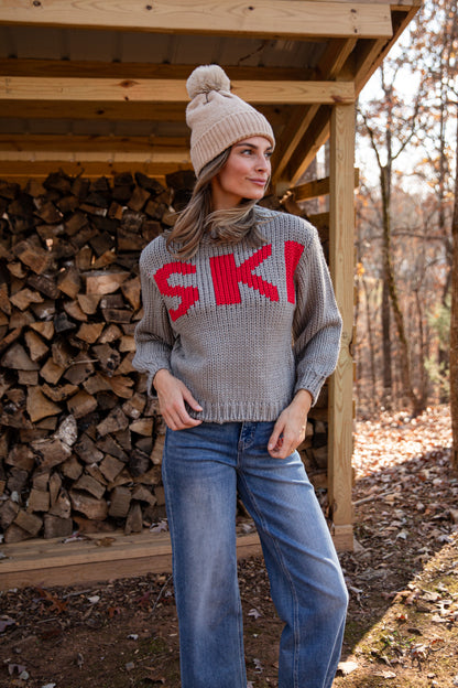 Woman wearing a gray sweater with &