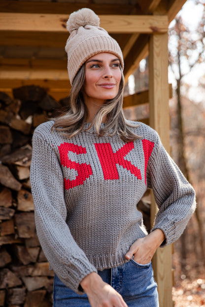 Woman wearing a gray sweater with &