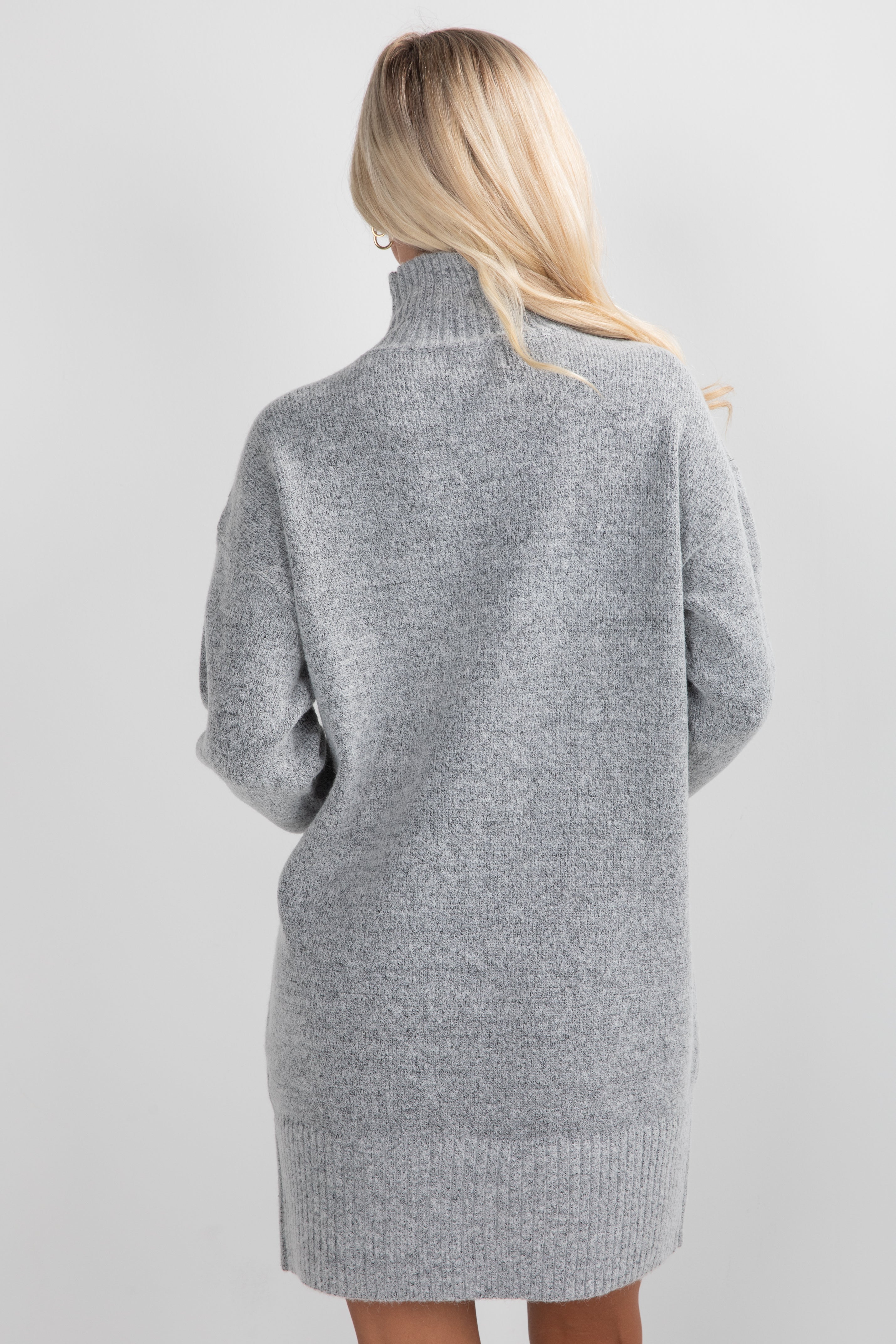 Gray sweater dress worn by a person on a light gray background