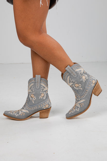 Gray embroidered cowboy boots on a white background
