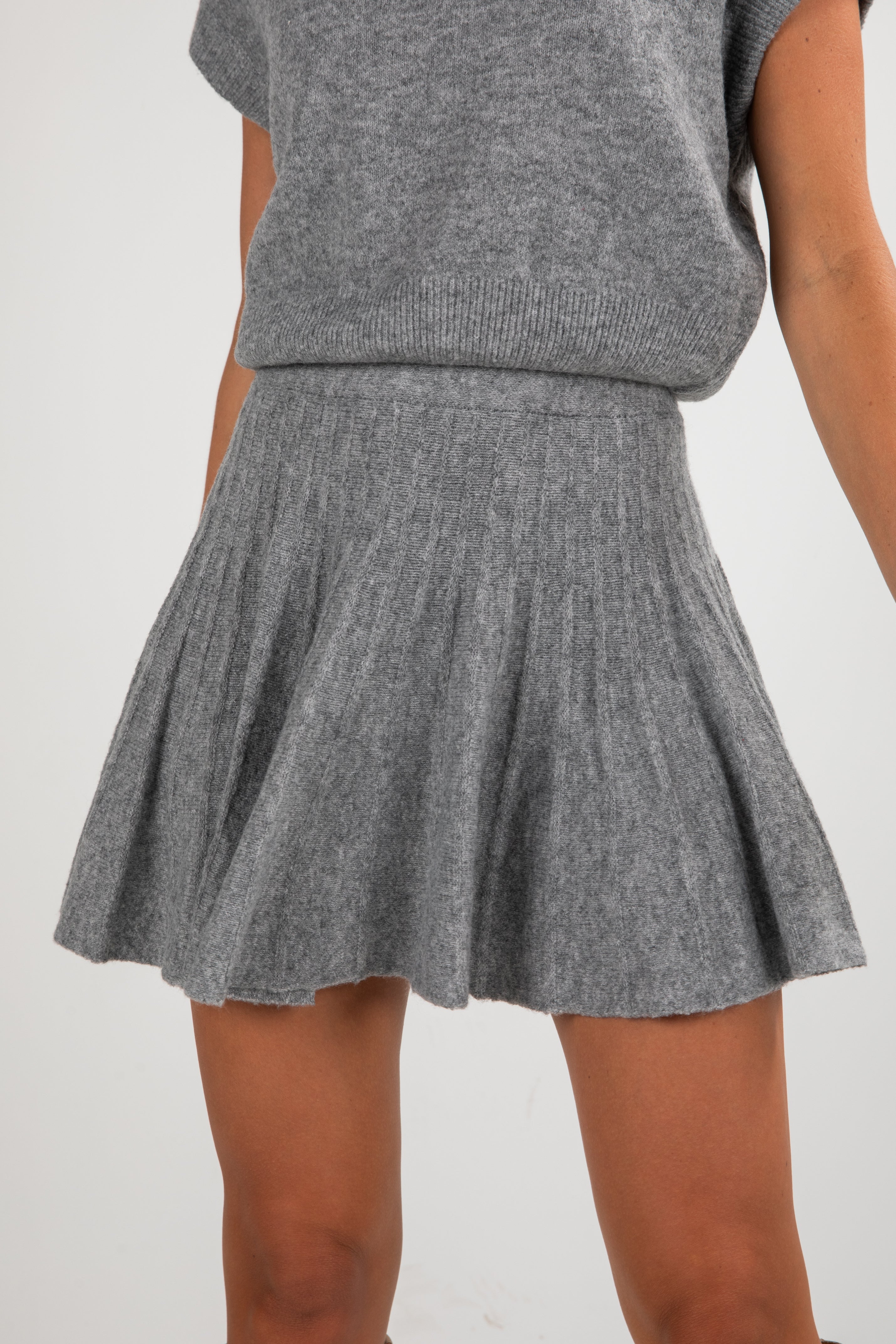 Gray knit sleeveless top and skirt set on a plain background