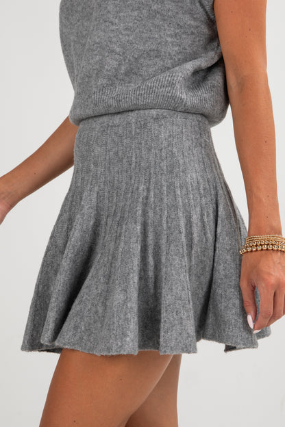Gray knit skirt worn by a person on a white background
