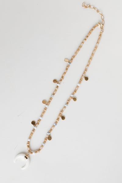 Gold Beaded Crescent Horn Necklace flat lay