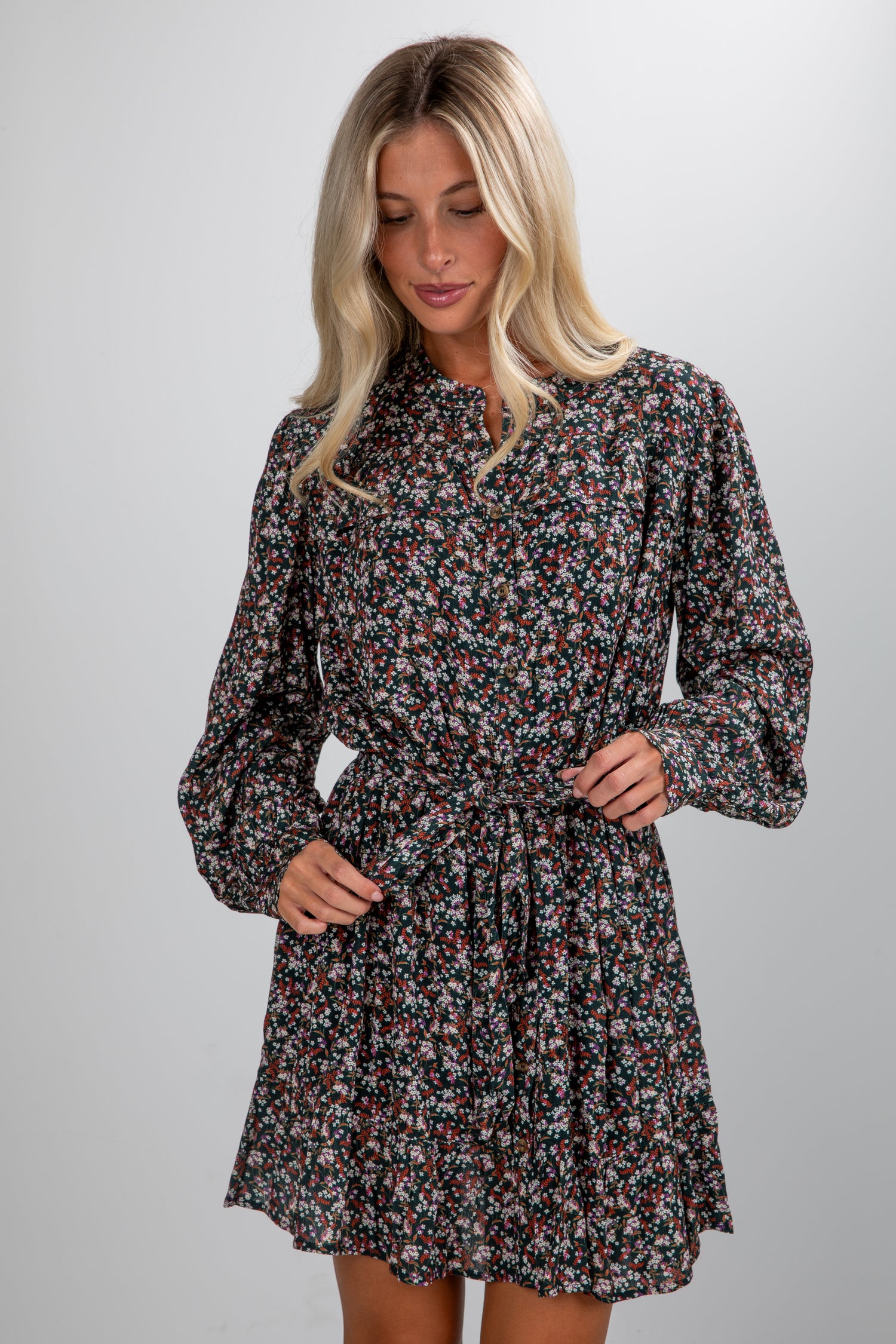 Woman wearing a floral dress against a plain background