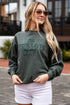 Woman wearing a green sweatshirt with &