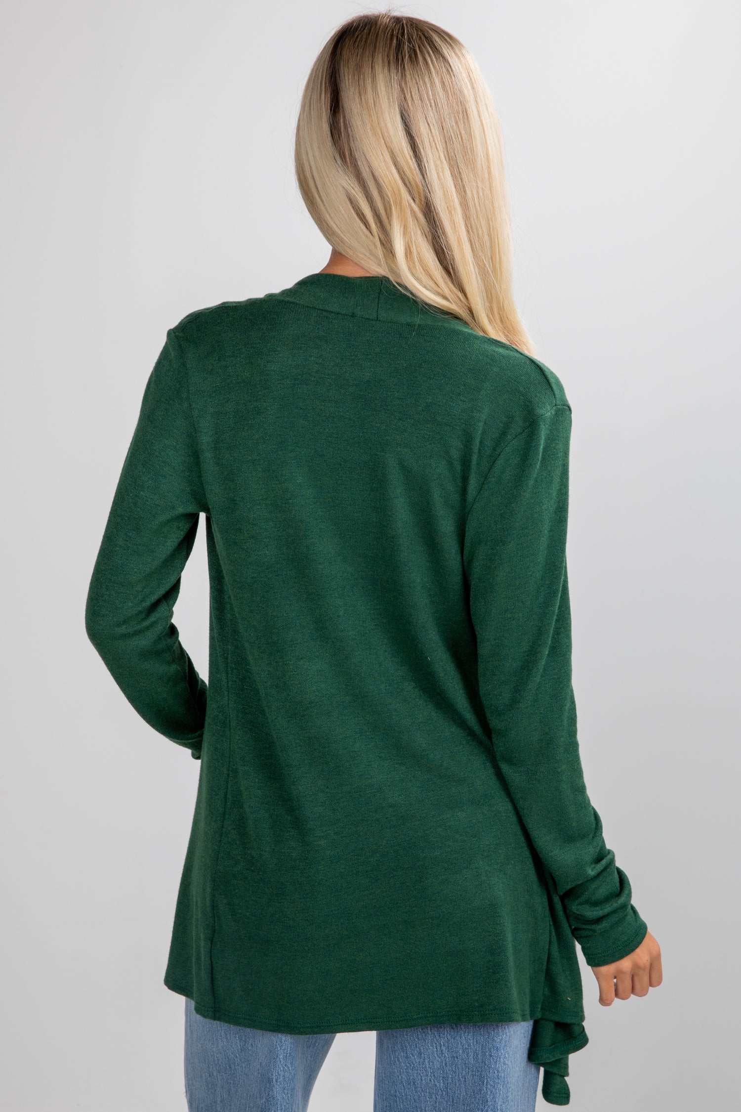 Person wearing a green cardigan on a plain background