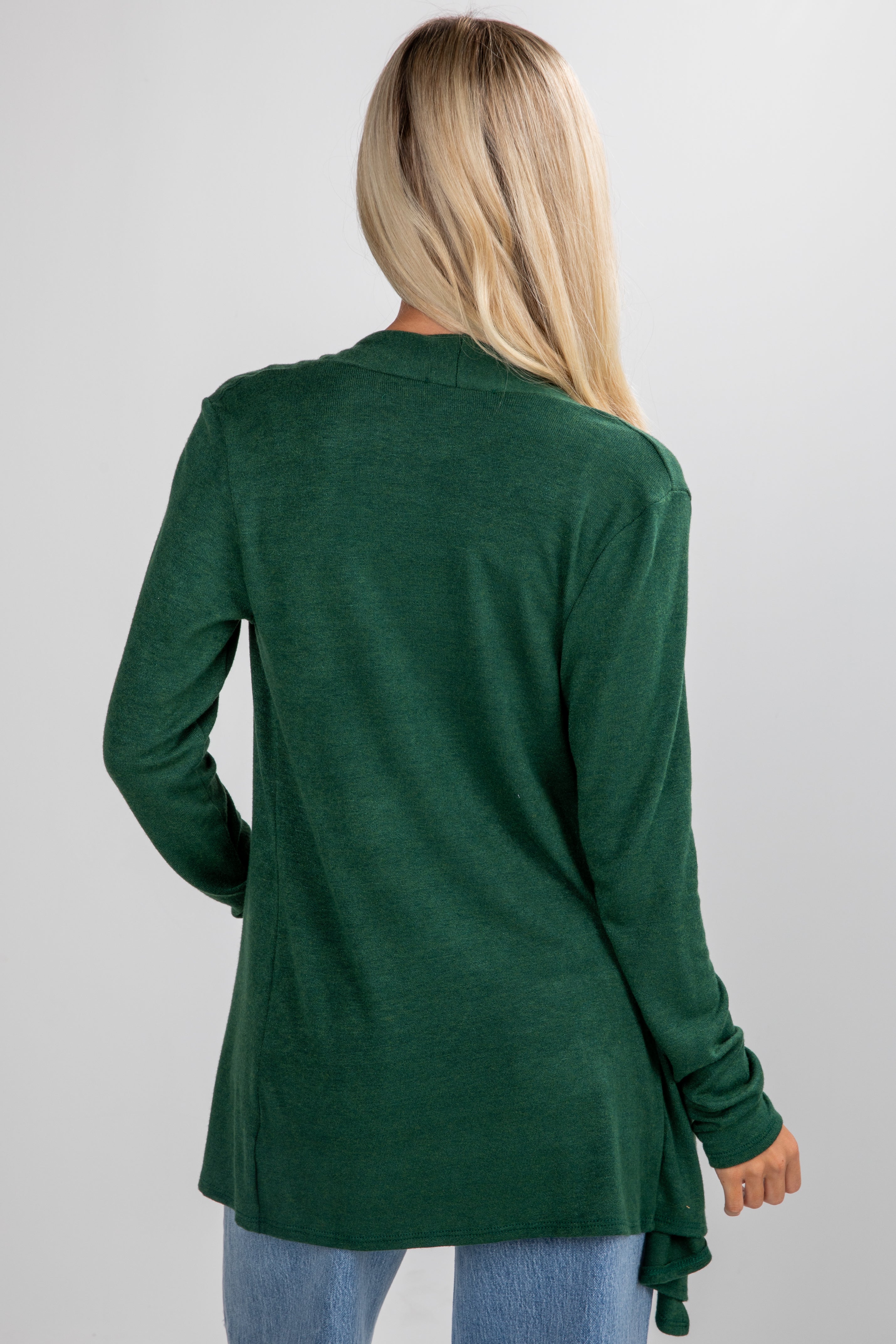 Person wearing a green cardigan on a plain background