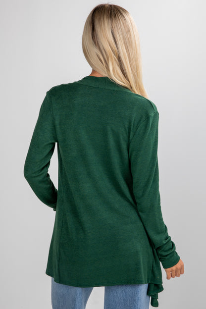 Person wearing a green cardigan on a plain background