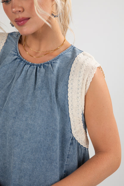 Woman wearing a blue dress with lace sleeves on a light gray background