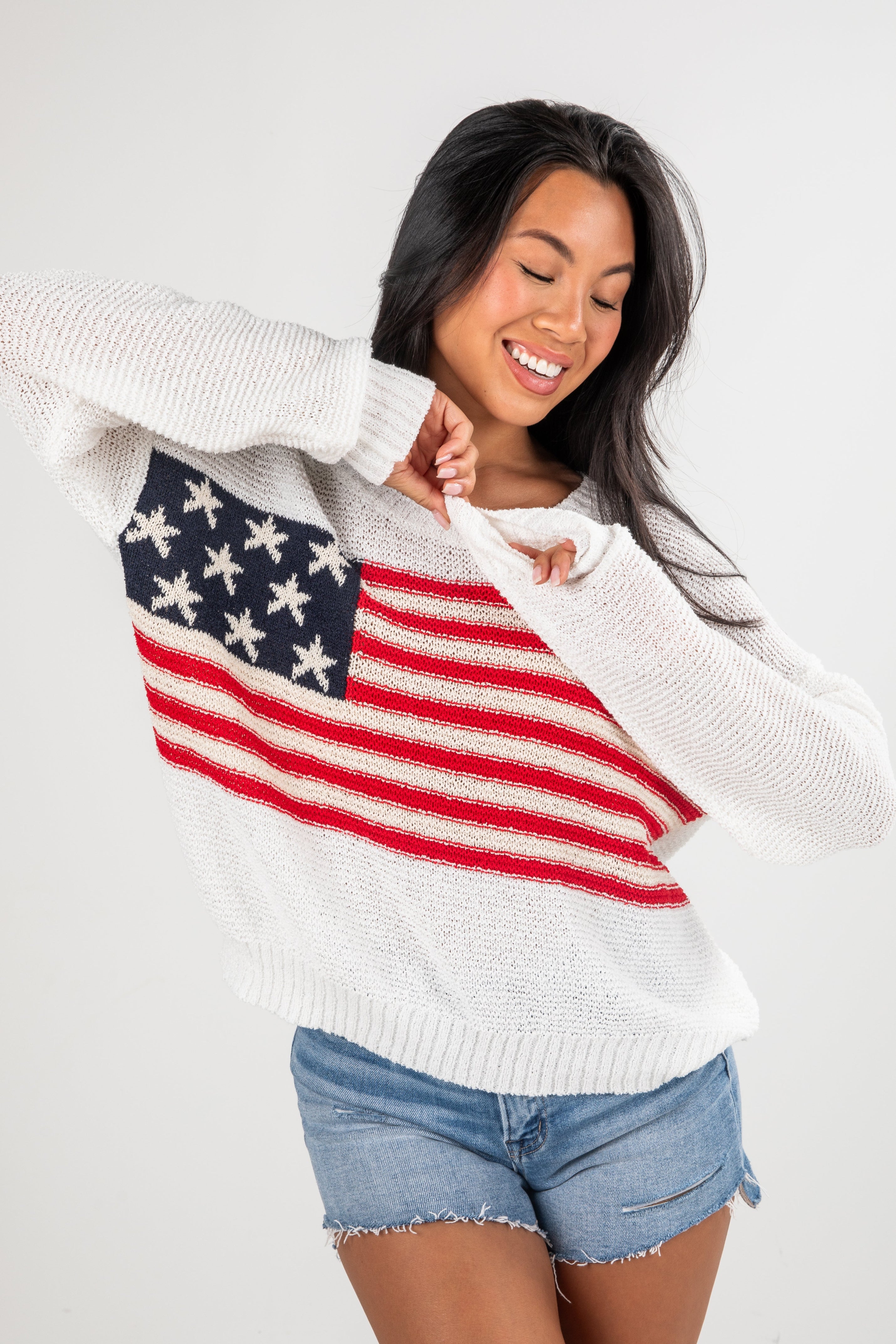 Woman wearing a sweater with an American flag design on a white background