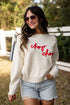 Woman wearing a white sweater with &