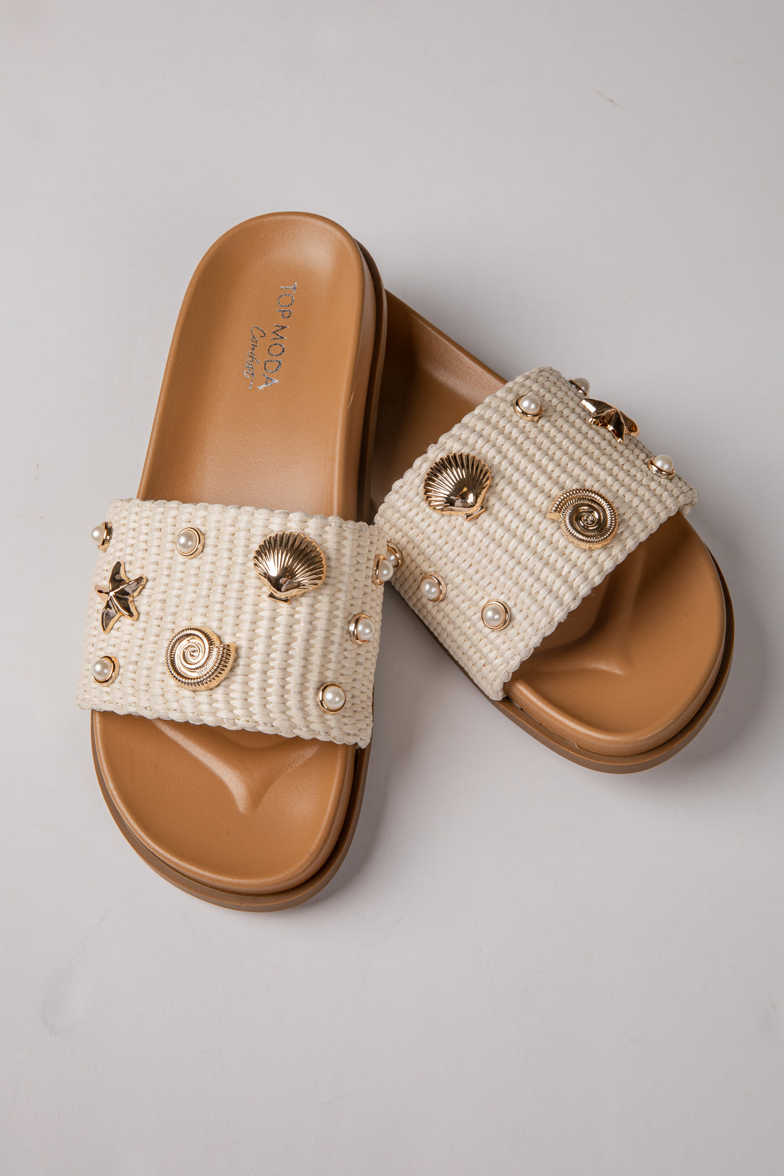 Pair of embellished sandals on a light gray background