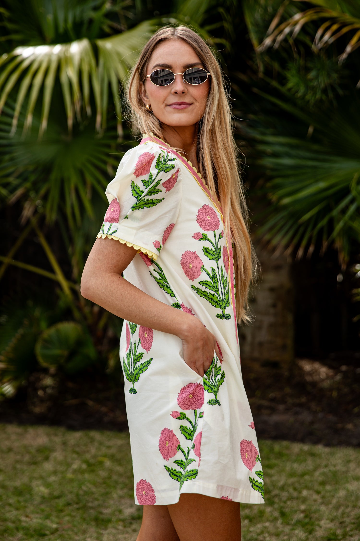 Woman wearing a floral dress with palm trees in the background
